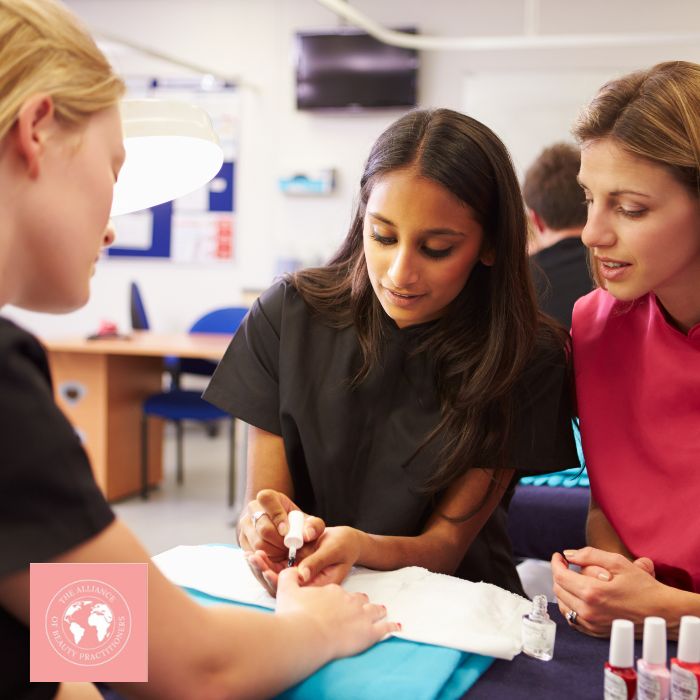 Alliance of Beauty Practitioners 2 female students are being taught manicures by a tutor