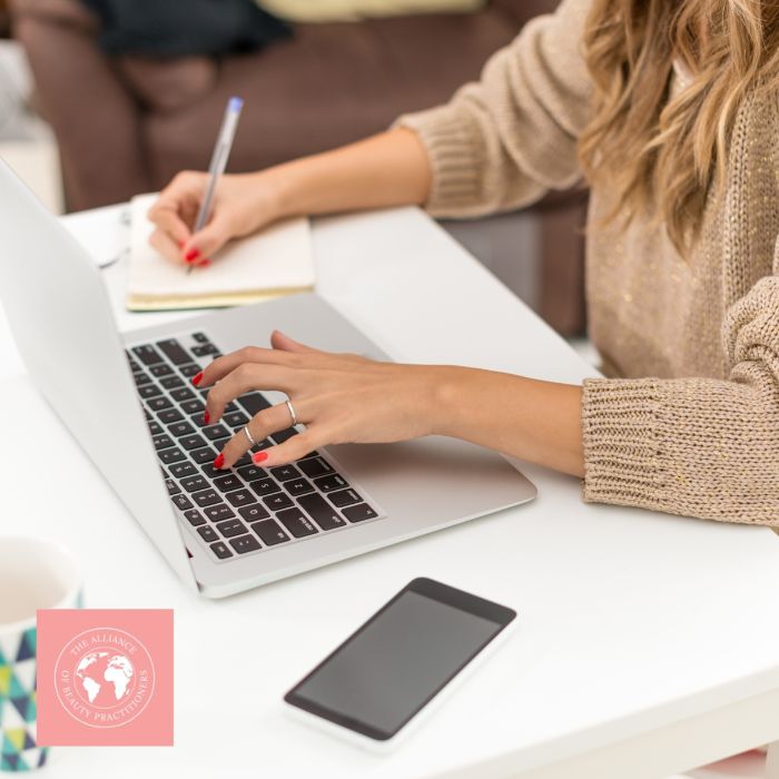 beauty training accreditation a lady with a laptop, notepad and pen