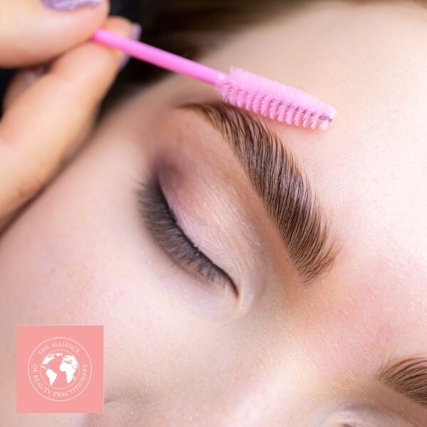a pink eyebrow comb being used during an eyebrow lamination course